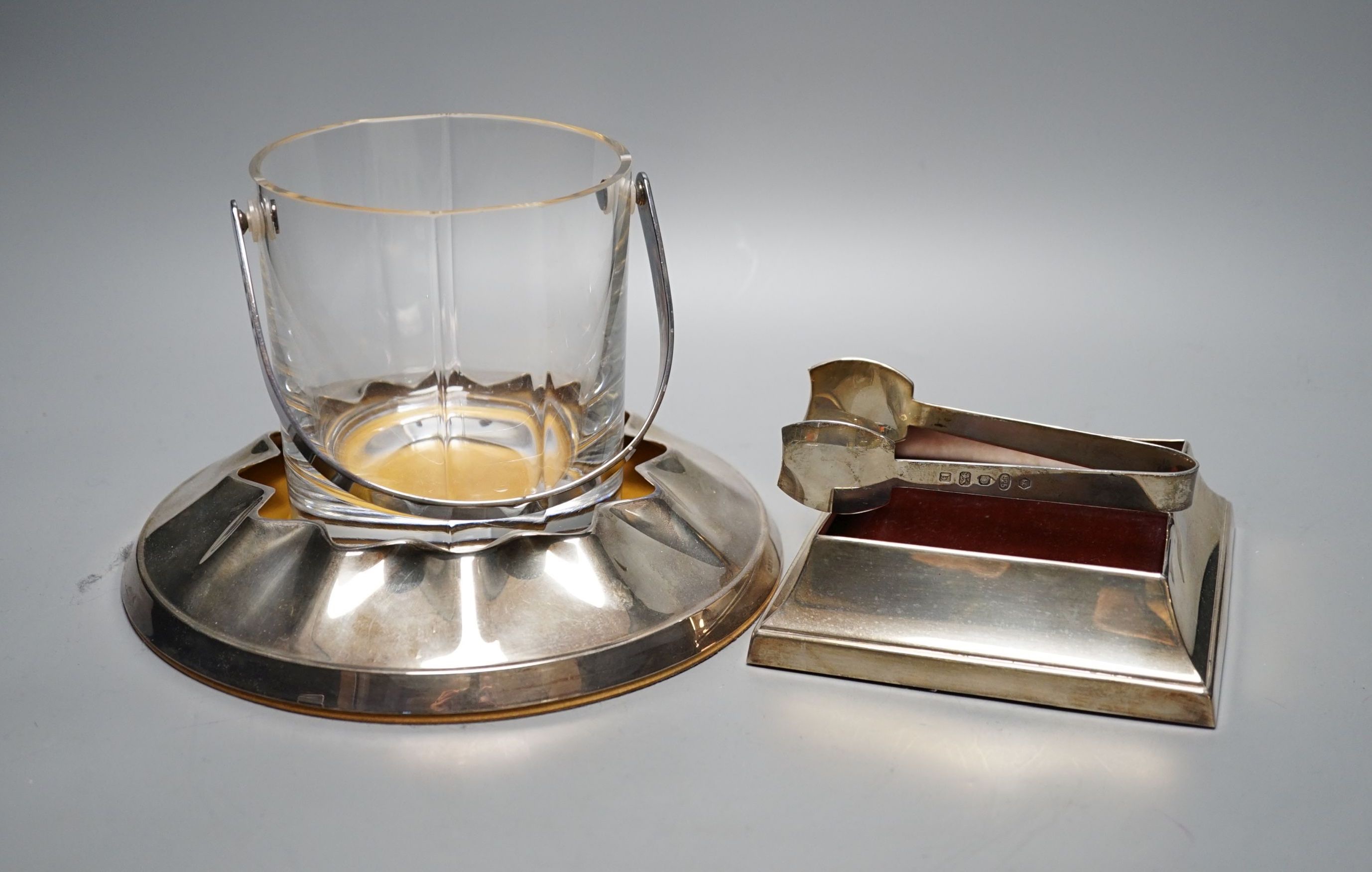 A modern silver mounted glass ice pale and matching tongs, Carrs of Sheffield, 2001, height 12.7cm, together with two modern silver mounted wooden stands.